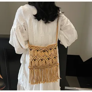 Detail of bohemian hand-woven crochet bag with wooden beads and long fringe tassels