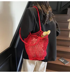 Detalle de bolso de punto rojo calado con bolsa interior blanca con cordón para el verano