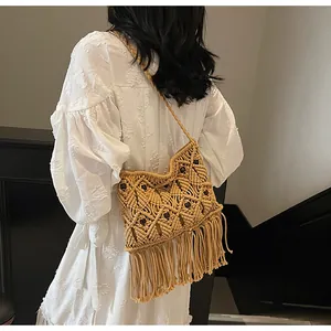 Detail of macrame shoulder bag with wooden beads and long fringes in bohemian style