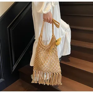Close-up of bohemian woven cotton shoulder bag with long tassels and hollow-out mesh design