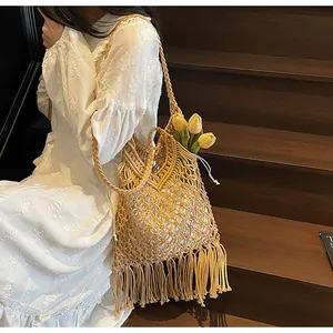 Detail of bohemian hand-woven tote bag featuring intricate tassels and a fabric inner lining