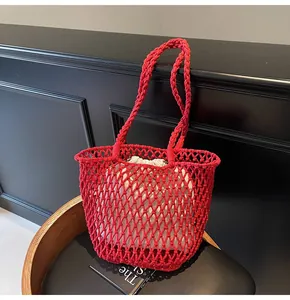 Detalle del bolso de playa de punto rojo con forro de lona sobre fondo de madera oscura