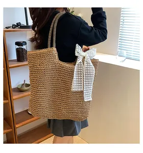 Straw tote bag with white lace bow and striped straps shown on model for size reference