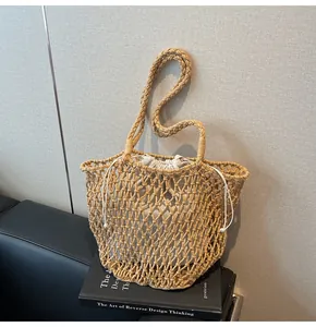 Detalle de bolso tote de punto calado con bolsa interior de crema y asas de cuerda gruesa