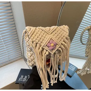 Gros plan d'un sac bandoulière en macramé avec de longues franges et détail floral
