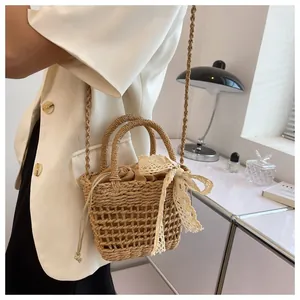 Detalle de bolso de playa de paja tejida beige con lazo de encaje y forro con cordón ajustable