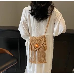 Détail du sac bandoulière tissé bohème avec des franges décoratives et un accent floral