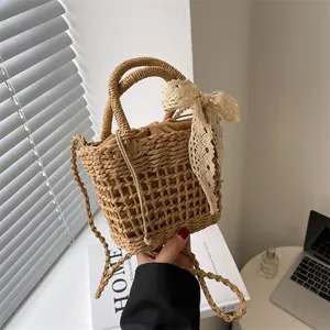 Detalle de bolso de paja trenzada con lazo de encaje y forro con cordón marrón