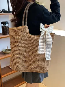 Handwoven straw beach tote with striped handles and large white lace bow decoration