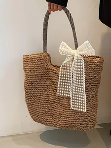 Large straw tote bag with black striped handles and white lace bow for summer beach style