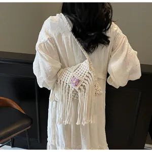 Détail d'un sac bandoulière bohème tissé avec fleur violette et longues franges