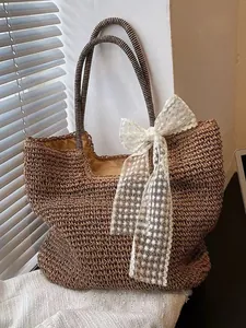 Brown woven beach tote with striped handles and a large white lace bow decoration