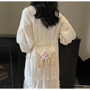 Vue détaillée du dos d'un sac bohème tissé avec de longues franges et une fleur violette