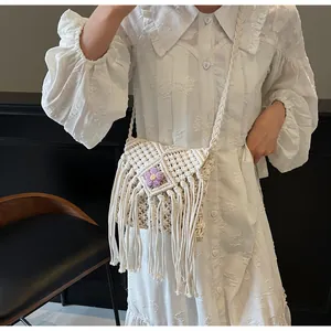 Détail du sac bandoulière bohème blanc tissé avec franges et fleur en crochet violette
