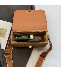 Detail of straw crossbody bag showing interior capacity for phone and cosmetics