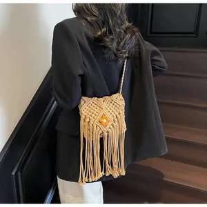Détail d'un sac bohème tissé avec franges, motif en losange et petite fleur orange