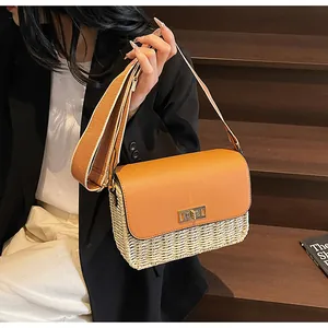 Detail of handwoven straw crossbody bag with brown leather flap and golden twist lock