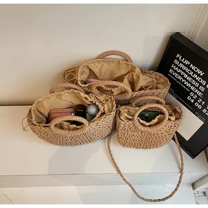Détail d'un ensemble de sacs en paille tressée avec doublure à cordon et poignées rondes