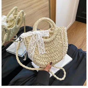 Dettaglio della borsa in paglia intrecciata con fiocco in pizzo e borsa interna con coulisse