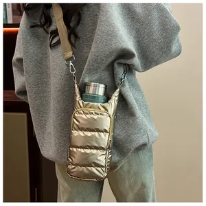Detailed view of champagne gold quilted puffer bottle bag with adjustable strap