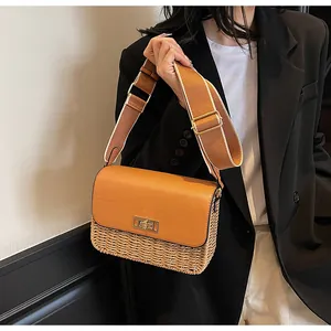 Detail of vintage straw woven bag featuring a brown flap and golden metal twist lock