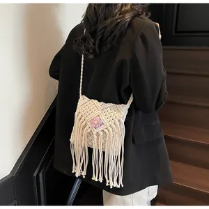 Détail du sac macramé bohème avec décoration de fleur violette et longues franges