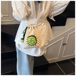 Detail der handgehäkelten Rosen-Beuteltasche mit weißer Strickstruktur und Kordelzug