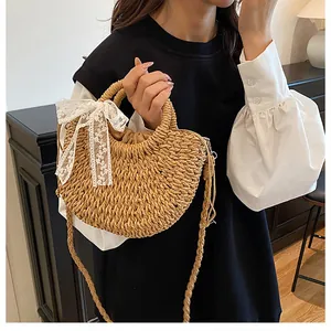 Dettaglio borsa di paglia intrecciata con fiocco in pizzo bianco e fodera a coulisse