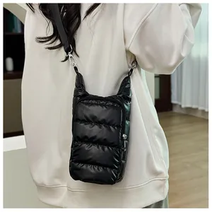 Side view of a black puffer crossbody water bottle bag with quilted texture and strap