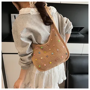 Detailed side view of a large woven tote bag with colorful beads on a model shoulder