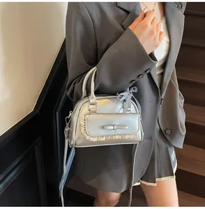 Detail of silver bowling bag with lace trim, bow accents and a checkered handle ribbon