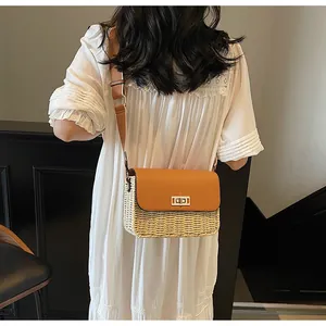 Detail of retro straw crossbody bag with brown leather flap and metal turn-lock closure