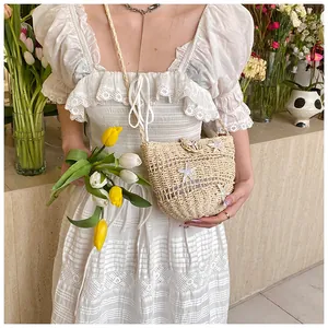 Détail du sac bandoulière en paille avec étoiles de mer blanches et accents de coquillages