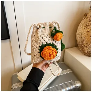 Nahaufnahme der handgefertigten Häkeltasche mit orangefarbenem Blumenmuster und Riemen