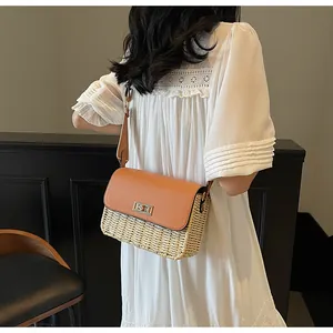 Detail of woven crossbody bag with brown leather flap and golden twist lock on a model