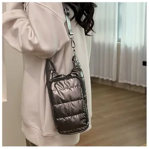 Detail of dark silver quilted down crossbody bag with cat ear design and metal strap hooks