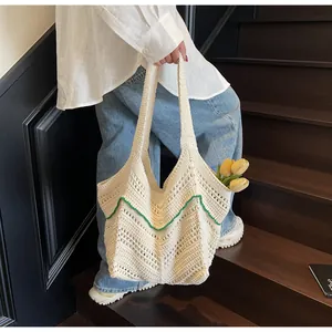 Detail of hand-crocheted tote bag featuring green wavy edges and fresh tulips inside