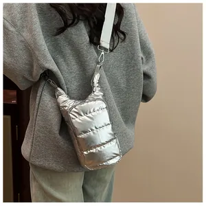 Side view of silver quilted crossbody bag with adjustable wide strap on model