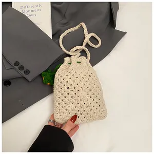 Nahaufnahme der cremefarbenen Häkeltasche mit Blattanhängern und feiner Webstruktur