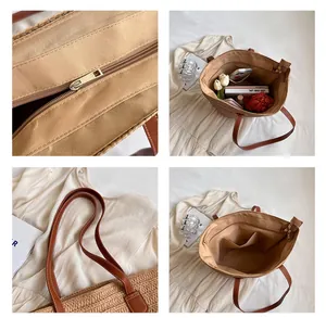 Detail view of woven straw tote bag featuring leather handles and interior zipper pocket