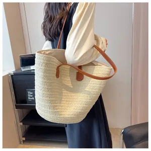 Vue détaillée du grand sac cabas tissé avec anses en cuir marron sur modèle