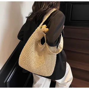 Dettaglio della borsa tote in paglia beige lavorata a uncinetto con texture traforata e fodera