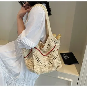 Detail of hand-crocheted beige tote bag with red wavy stitching and openwork pattern