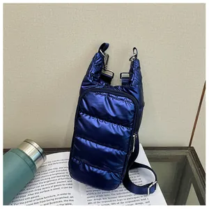 Detail of navy blue quilted puffer crossbody bag with shiny finish and zipper pocket