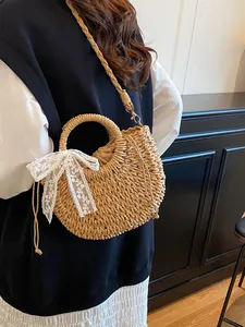Borsa a mano artigianale in paglia intrecciata con fiocco in pizzo bianco e manico rotondo