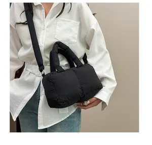 Dettaglio di una borsa trapuntata nera con tracolla regolabile e morbido tessuto in nylon