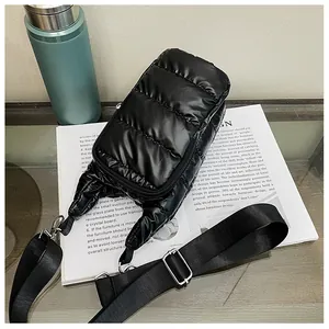 Top view of black quilted down-style crossbody bag with zipper and shiny nylon texture