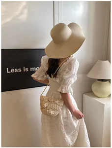Détail du sac en paille avec accents d'étoiles de mer et robe en dentelle élégante en été