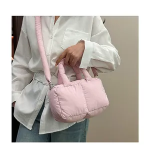 Dettaglio della borsa imbottita rosa in nylon con tracolla spessa e manico morbido