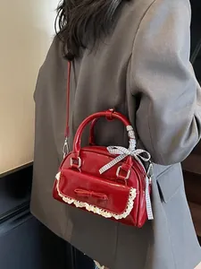 Red bow bowling bag with white lace trim and checkered ribbon in a stylish crossbody view